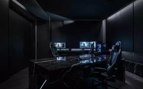 Ein minimalistisch gestalteter, dunkler Gaming-Raum mit indirekter Beleuchtung und einer glatten, reflektierenden Tischoberfläche. - Foto: über boerse-global.de