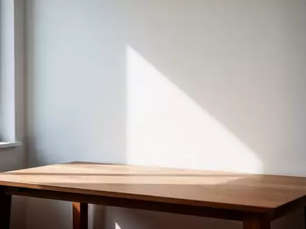 Minimalistischer Arbeitsplatz mit weichem Tageslicht und sanften Farbverläufen an einer leeren Wand. - Foto: über boerse-global.de