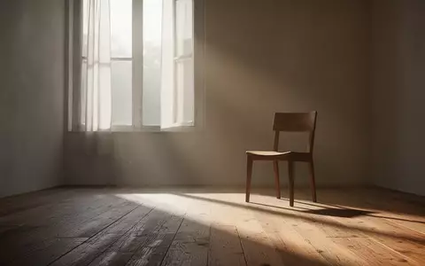 Ein minimalistischer, sonnendurchfluteter Raum mit einem leeren Stuhl vor einem Fenster, der Ruhe und Heilung symbolisiert. - Foto: über boerse-global.de