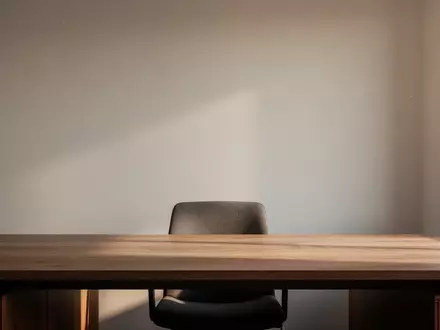 Ein minimalistischer, moderner Arbeitsplatz mit einem Holztisch und natürlichem Licht, das sanfte Schatten wirft. - Foto: über boerse-global.de
