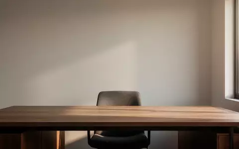 Ein minimalistischer, moderner Arbeitsplatz mit einem Holztisch und natürlichem Licht, das sanfte Schatten wirft. - Foto: über boerse-global.de