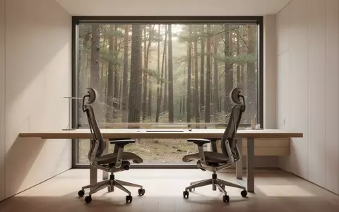 Ein minimalistisch eingerichteter, aufgeräumter Arbeitsplatz mit Holztisch und Blick in einen sonnigen Wald. - Foto: über boerse-global.de