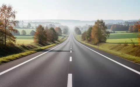 Eine leere, moderne Autobahn erstreckt sich durch eine grüne europäische Landschaft bei hellem Tageslicht. - Foto: über boerse-global.de