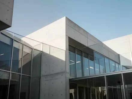 Ein modernes, minimalistisches Behördengebäude mit klaren architektonischen Linien und großen Glasfronten bei Tageslicht. - Foto: über boerse-global.de