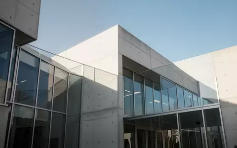 Ein modernes, minimalistisches Behördengebäude mit klaren architektonischen Linien und großen Glasfronten bei Tageslicht. - Foto: über boerse-global.de