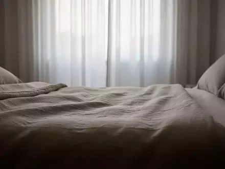 Ein minimalistisch gestaltetes, ruhiges Schlafzimmer mit sanftem Tageslicht, das eine entspannte Atmosphäre vermittelt. - Foto: über boerse-global.de