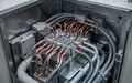 Nahaufnahme einer industriellen Schaltanlage mit komplexer Verkabelung und elektrischen Komponenten in einem Metallgehäuse. - Foto: über boerse-global.de