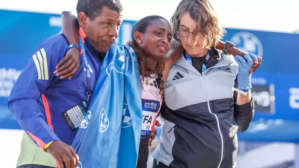Von Lauf-Legende und ihrem Coach Haile Gebrselassie (l) musste Assefa im Ziel gestützt werden. - Bild: Andreas Gora/dpa