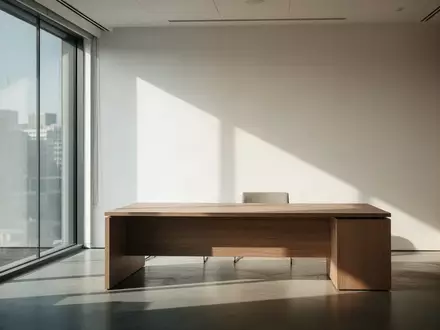 Ein heller, leerer Büroraum mit modernem Interieur und einfallendem Tageslicht, das Schatten auf eine leere Schreibtischoberfläche wirft. - Foto: über boerse-global.de