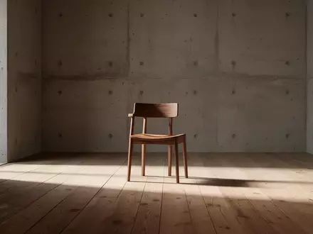 Ein minimalistischer, leerer Raum mit einem einzelnen Holzstuhl in natürlichem Sonnenlicht, der Stille und Reduktion symbolisiert. - Foto: über boerse-global.de