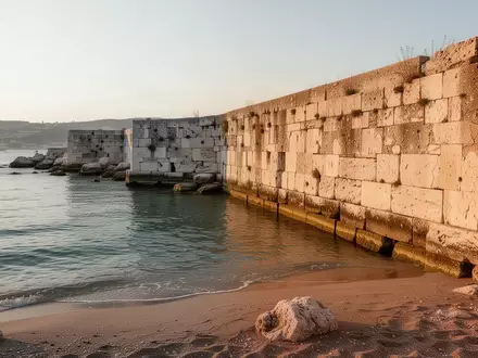 Die historische Trennmauer am Strandbad Pedocìn in Triest bei ruhigem Tageslicht. - Foto: über boerse-global.de