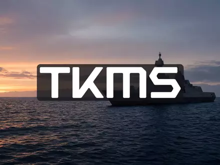 Modernes Marineschiff vor einer Küstenlinie bei Dämmerung, symbolisiert maritime Verteidigungstechnologie. - Foto: über boerse-global.de