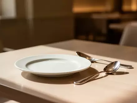 Ein minimalistisch gedeckter Tisch in einem eleganten Restaurant mit einem leeren Dessertteller und einem Kaffeelöffel. - Foto: über boerse-global.de