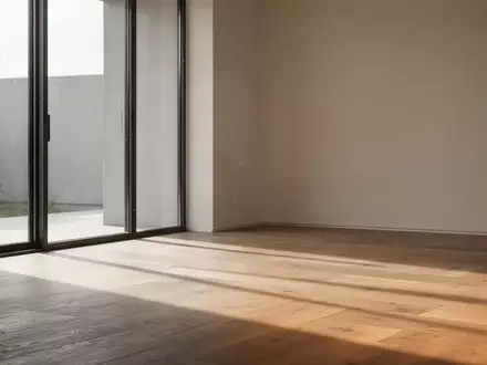 Ein minimalistischer Raum mit weichem Tageslicht und Schattenwurf auf einem Holzboden. - Foto: über boerse-global.de