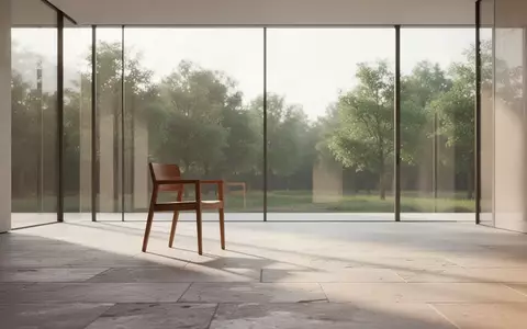 Ein heller, minimalistischer Raum mit einem leeren Stuhl vor einem großen Fenster, das auf eine ruhige Landschaft blickt. - Foto: über boerse-global.de
