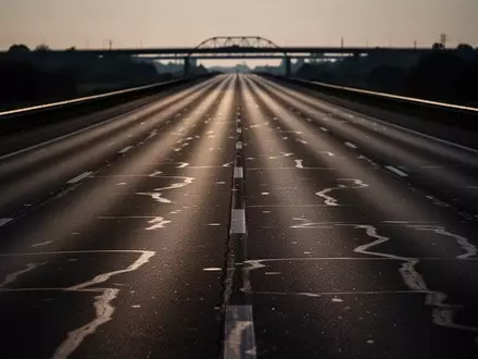 Eine leere, mehrspurige Autobahn im Dämmerlicht, die sich bis zum Horizont erstreckt. - Foto: über boerse-global.de