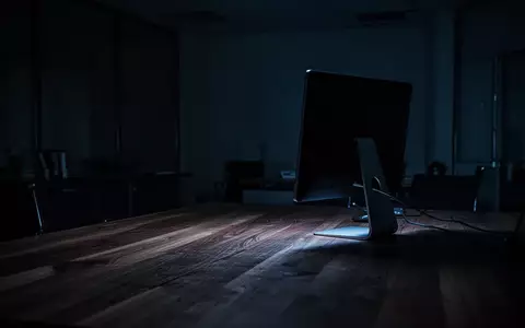 Ein dunkles, leeres Büro bei Nacht mit dem schwachen blauen Licht eines ausgeschalteten Computerbildschirms. - Foto: über boerse-global.de