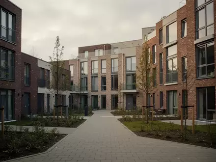 Ein modernes Wohngebäude in den Niederlanden mit Backsteinfassade und begrünten Außenanlagen bei bewölktem Himmel. - Foto: über boerse-global.de