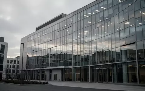 Ein modernes Bürogebäude mit Glasfassade bei bewölktem Himmel ohne sichtbare Personen oder Beschilderung. - Foto: über boerse-global.de