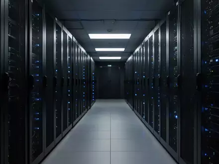 Ein dunkler Serverraum mit leuchtenden Indikatorlichtern an den Racks. - Foto: über boerse-global.de