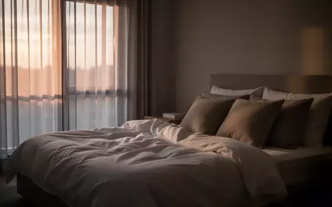 Ein ungemachtes Bett in einem ruhig beleuchteten Schlafzimmer am Morgen, das eine friedliche Atmosphäre vermittelt. - Foto: über boerse-global.de