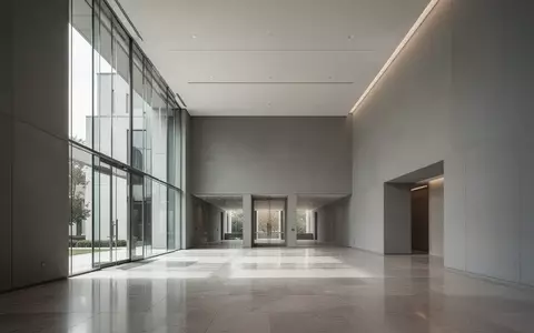 Ein minimalistischer, moderner Innenraum eines Regierungsgebäudes mit hellen Steinböden und großen Glasfronten. - Foto: über boerse-global.de