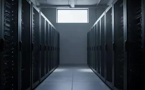 Eine Reihe dunkler, inaktiver Serverracks in einem modern gestalteten, minimalistischen Serverraum. - Foto: über boerse-global.de