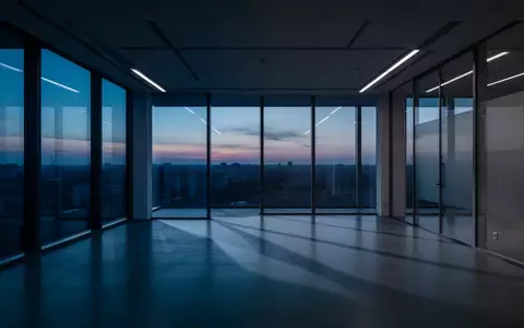 Ein leeres, modernes Bürogebäude in der Dämmerung mit kühlem Licht und langen Schatten. - Foto: über boerse-global.de