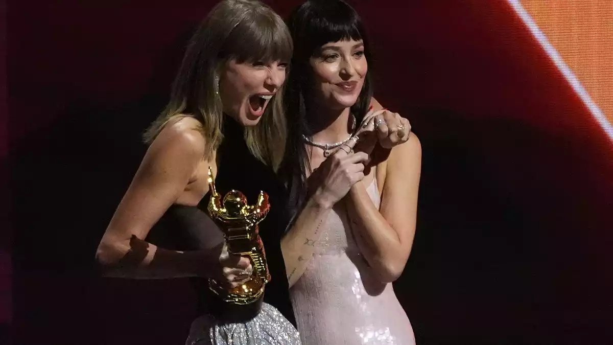 Dakota Johnson überreicht Taylor Swift den Sonderpreis.  - Bild: Chris Pizzello/Invision/AP/dpa