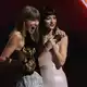 Dakota Johnson überreicht Taylor Swift den Sonderpreis.  - Bild: Chris Pizzello/Invision/AP/dpa