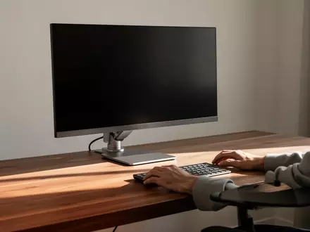 Ein minimalistischer, aufgeräumter Schreibtisch mit einem ausgeschalteten Monitor vor einem hellen Fenster. - Foto: über boerse-global.de