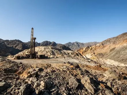 Industrielle Bohrausrüstung auf einem abgelegenen Minengelände in einer felsigen Landschaft. - Foto: über boerse-global.de