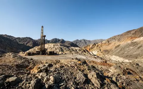 Industrielle Bohrausrüstung auf einem abgelegenen Minengelände in einer felsigen Landschaft. - Foto: über boerse-global.de