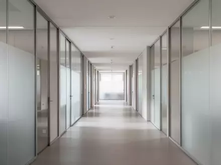 Ein heller, minimalistischer Flur in einem modernen Verwaltungsgebäude mit neutralen Farben und natürlichem Licht. - Foto: über boerse-global.de
