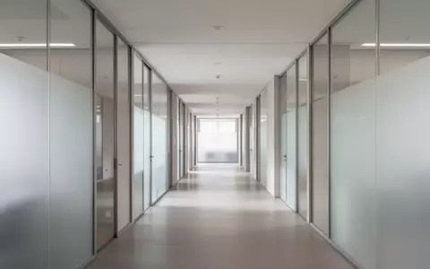 Ein heller, minimalistischer Flur in einem modernen Verwaltungsgebäude mit neutralen Farben und natürlichem Licht. - Foto: über boerse-global.de