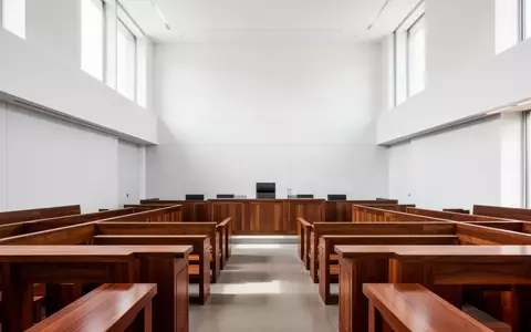 Ein minimalistischer, heller Gerichtssaal mit HolzbĂ€nken und natĂŒrlichem Lichteinfall. - Foto: ĂŒber boerse-global.de