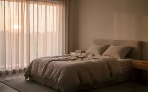 Ein minimalistisch eingerichtetes, ruhiges Schlafzimmer bei Tagesanbruch mit weichem, natürlichem Licht. - Foto: über boerse-global.de