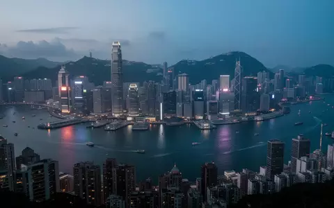 Nächtliche Skyline von Hongkong mit Blick auf das Finanzviertel über dem Hafen bei Dämmerung. - Foto: über boerse-global.de