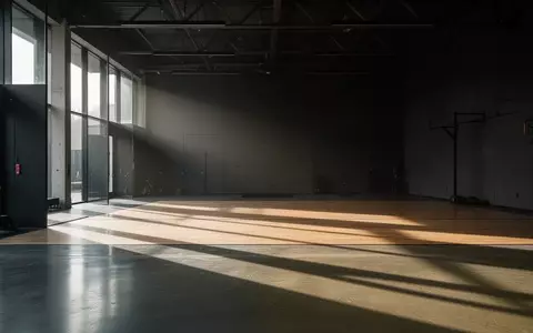 Minimalistischer, leerer Trainingsraum mit poliertem Betonboden und dezentem Lichteinfall. - Foto: über boerse-global.de