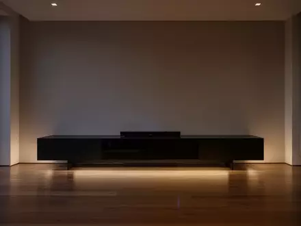 Ein minimalistisch gestaltetes Wohnzimmer mit einem modernen Medienmöbel in einer ruhigen, atmosphärischen Beleuchtung. - Foto: über boerse-global.de