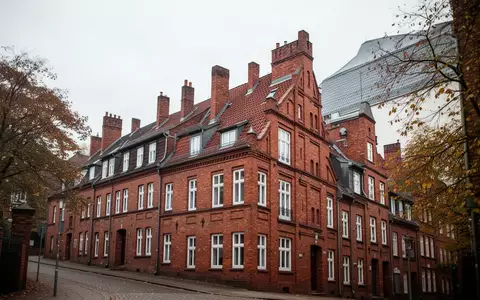 Reihenhauszeile aus rotem Backstein in einer deutschen Stadt bei bewölktem Herbstwetter. - Foto: über boerse-global.de