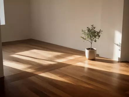Ein minimalistischer, lichtdurchfluteter Raum mit klaren architektonischen Linien und einer einzelnen Pflanze. - Foto: über boerse-global.de