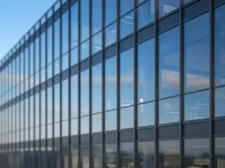 Moderne Glasfassade eines Bürogebäudes bei Tageslicht. - Foto: über boerse-global.de