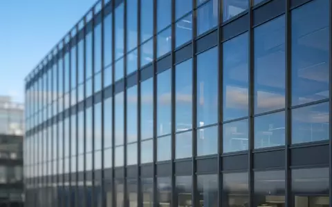Moderne Glasfassade eines Bürogebäudes bei Tageslicht. - Foto: über boerse-global.de