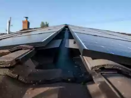Nahaufnahme eines geneigten Solarmoduls auf einem Dach mit einem dunklen Hohlraum zwischen der Anlage und den Dachziegeln. - Foto: über boerse-global.de