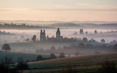 Morgenstimmung mit nebliger Hügellandschaft und den Silhouetten alter Kirchtürme in der Ferne - Foto: über boerse-global.de
