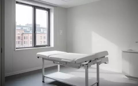 Ein minimalistischer, leerer Behandlungsraum in einer modernen Klinik mit hellem Tageslicht. - Foto: über boerse-global.de