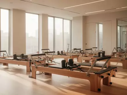 Ein heller, minimalistischer Raum mit leeren Pilates-Reformer-Geräten in einem modernen Studio bei natürlichem Tageslicht. - Foto: über boerse-global.de