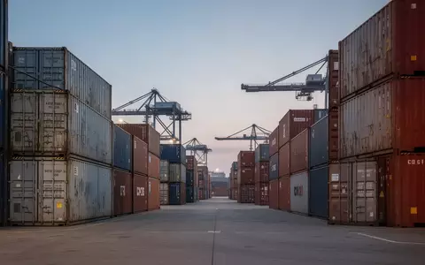 Containerstapel in einem modernen Logistikhafen bei Dämmerung - Foto: über boerse-global.de