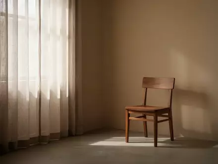 Ein minimalistisch eingerichteter, ruhiger Raum mit sanftem Tageslicht, das durch einen Vorhang in eine leere Ecke fällt. - Foto: über boerse-global.de